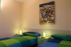 MoliternoにあるB&B Sogni D'Oroの壁に絵画が飾られた部屋のベッド2台
