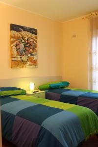 two beds in a room with a painting on the wall at B&B Sogni D'Oro in Moliterno