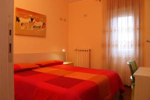 a bedroom with a red bed and a window at B&B Sogni D'Oro in Moliterno