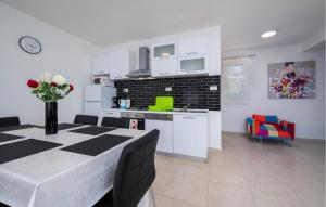 een keuken en eetkamer met een tafel met bloemen erop bij Awesome Home In Sveti Lovrec Labinski in Diminići