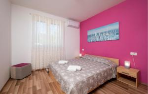 een slaapkamer met roze muren en een bed met 2 handdoeken bij Awesome Home In Sveti Lovrec Labinski in Diminići +27 foto's