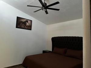 una camera con ventilatore a soffitto e letto di Hotel Paris inn a Mazamitla