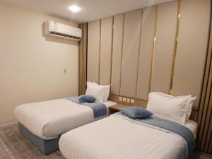 a hotel room with two beds and a heater at شقق العنود والجوهرة للشقق المخدومة in Hafr Al Baten