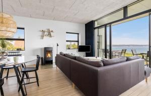 a living room with a large couch and a table with a fireplace at Three-Bedroom Holiday Home In Borkop in Børkop
