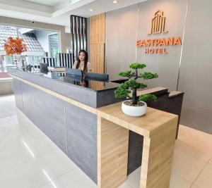 a woman standing at the reception desk of an eskinara hotel at Eastpana Hotel 304 Prachinburi in Si Maha Phot +58 photos