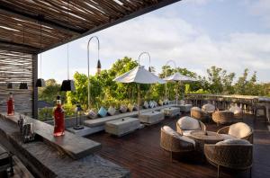 a patio with couches and chairs on a wooden deck at Cross Bali Breakers - formerly X2 Bali Breakers in Jimbaran