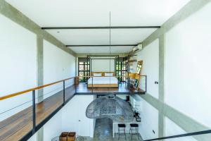 Habitación con balcón, cama y mesa. en Urban Oasis Loft by GORO, en Canggu