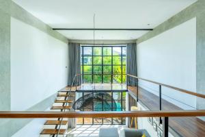 Habitación con escaleras y ventana grande. en Urban Oasis Loft by GORO, en Canggu