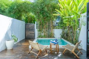 Un patio con sillas y una piscina. en Urban Oasis Loft by GORO, en Canggu