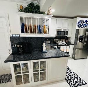 a kitchen with white cabinets and a black counter top at Mathel and Mar in West Palm Beach