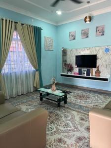 a living room with a couch and a tv at Homestay Salak 756 at Sungai Siput Kuala Kangsar for Islamic Guest Only in Sungai Siput