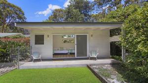 a house with two chairs and a patio at Casa Bianca - Pearl Beach in Pearl Beach +9 photos