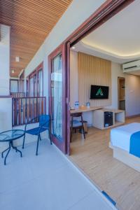 ein Schlafzimmer mit einem Bett und einem Tisch und Stühlen in der Unterkunft ABISHA Hotel Sanur in Sanur