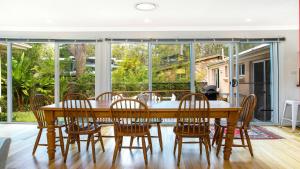 ein Esszimmer mit einem Holztisch und Stühlen in der Unterkunft Paradise - Pearl - Modern With Wifi in Pearl Beach