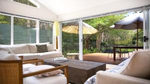 ein Wohnzimmer mit einem Sofa und einem Sonnenschirm in der Unterkunft Paradise - Pearl - Modern With Wifi in Pearl Beach