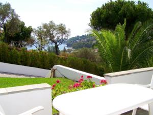 a view of a garden with white chairs and flowers at Villa Anna Maria in Agia Paraskevi