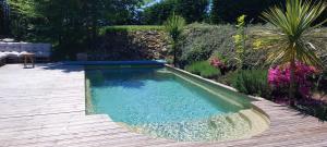a swimming pool in the middle of a garden at Clos Baroanni - La Volière, chambre en duplex in Terraube
