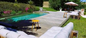 a swimming pool on a wooden deck next to a backyard at Clos Baroanni - La Volière, chambre en duplex in Terraube +12 photos