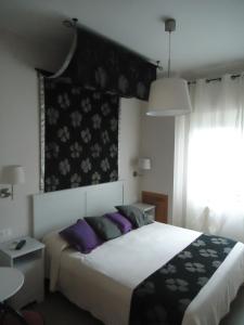 ein Schlafzimmer mit einem großen Bett mit lila Kissen in der Unterkunft Pensione Campese in Formia
