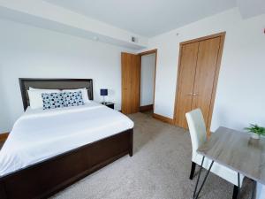 Un dormitorio con una cama, un escritorio y una mesa. en 2 Luxury suites with parking at The Grand Castle, en Grandville