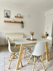 Un comedor con una mesa y sillas blancas. en Departamento Céntrico Belgrano 2, en San Carlos de Bariloche