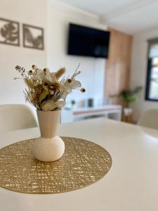 un jarrón con flores sentado en una mesa en Departamento Céntrico Belgrano 2, en San Carlos de Bariloche