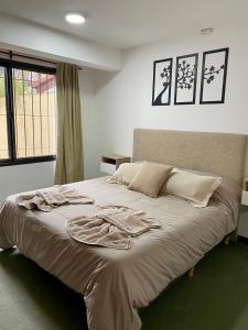 Una cama con una bata en un dormitorio en Departamento Céntrico Belgrano 2, en San Carlos de Bariloche