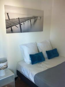 カップ・ダグドにあるAppartement Cap D'Agdeのベッド1台(青い枕2つ付)と桟橋の写真