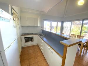 eine Küche mit schwarzer Arbeitsplatte und Kühlschrank in der Unterkunft Osprey Holiday Village Unit 118 in Exmouth