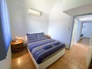 ein Schlafzimmer mit einem Bett mit blauen Kissen darauf in der Unterkunft Osprey Holiday Village Unit 118 in Exmouth + 10 Fotos