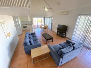 ein Wohnzimmer mit zwei blauen Sofas und einem Tisch in der Unterkunft Osprey Holiday Village Unit 118 in Exmouth