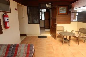 a living room with a table and a fire extinguisher at Banjai Garden Guesthouse in Chiang Mai