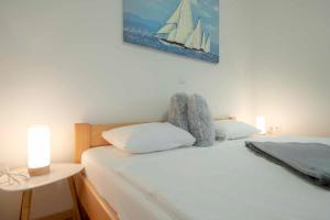 a bedroom with a bed with a sailboat picture on the wall at Apartment Nina in Slunj