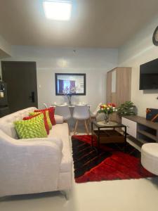 a living room with a white couch and a table at Kral Suite in Las Piñas in Manila