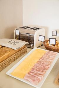 Montano Boutique Suites في إل كالافاتي: مطبخ مع طاولة للحوم ومحمصة خبز