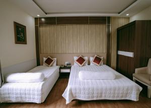 a bedroom with two beds with white sheets at Thuan Phat House Soc Trang in Soc Trang +60 photos