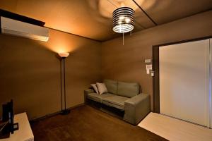 a living room with a couch and a lamp at Green Room - グリーンルーム志摩 in Shima
