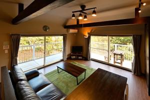 a living room with a couch and a table at Green Room - グリーンルーム志摩 in Shima
