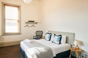 a bedroom with a bed with blue and white pillows at Healesville Hotel in Healesville +31 photos
