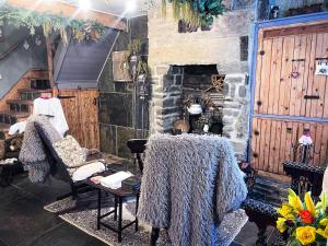Zimmer mit 2 Stühlen und einem Steinkamin in der Unterkunft Travel Back in Time Fairy Cottage on the Cobbles an Experience Property in Haworth