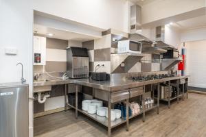 a large kitchen with stainless steel counters and appliances at Tequila Sunrise Potts Point in Sydney