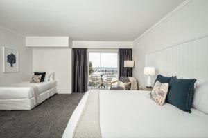Una habitación de hotel con una gran cama blanca y un balcón. en Anchorage Port Stephens, en Nelson Bay 32 fotos más