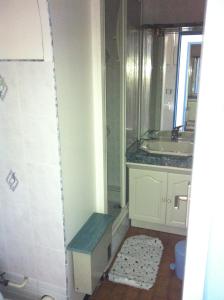 Appartement Cap D'Agde في كاب داغد: حمام مع حوض ودش مع مقعد