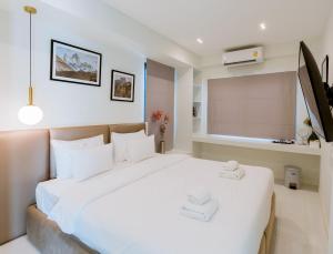 a bedroom with a large white bed in a room at ฟูจิ พูลวิลลา เขาใหญ่ Fuji Pool Villa Khaoyai in Wangkata