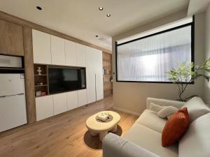 a living room with a white couch and a large window at 同济佳苑公寓 in Shanghai +37 photos