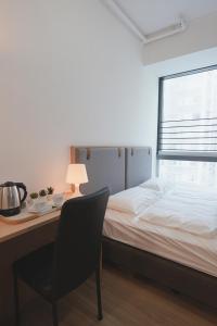 una camera con letto e scrivania con sedia di China Rich Oriental Hotel a Hong Kong