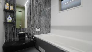 a bathroom with a shower and a sink and a mirror at HANASTAY花渓居 椿Tsubaki in Osaka +86 photos