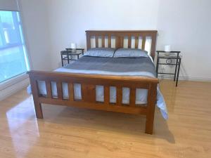 a wooden bed in a room with two end tables at Dunes Getaway in Port Hughes