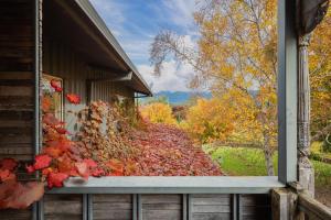 a window of a house with autumn leaves on a porch at Peggy Adelaide Suite in Porepunkah