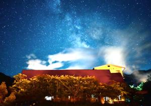 un edificio sotto un cielo notturno con le stelle di 筋肉と自然と遊ぶ宿 田島館 a Takayama